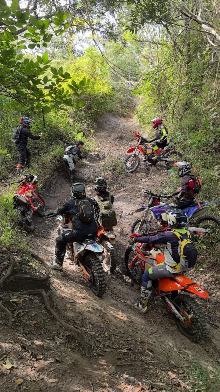 Dirtbike riders climbing a rocky jungle trail in Costa Rica