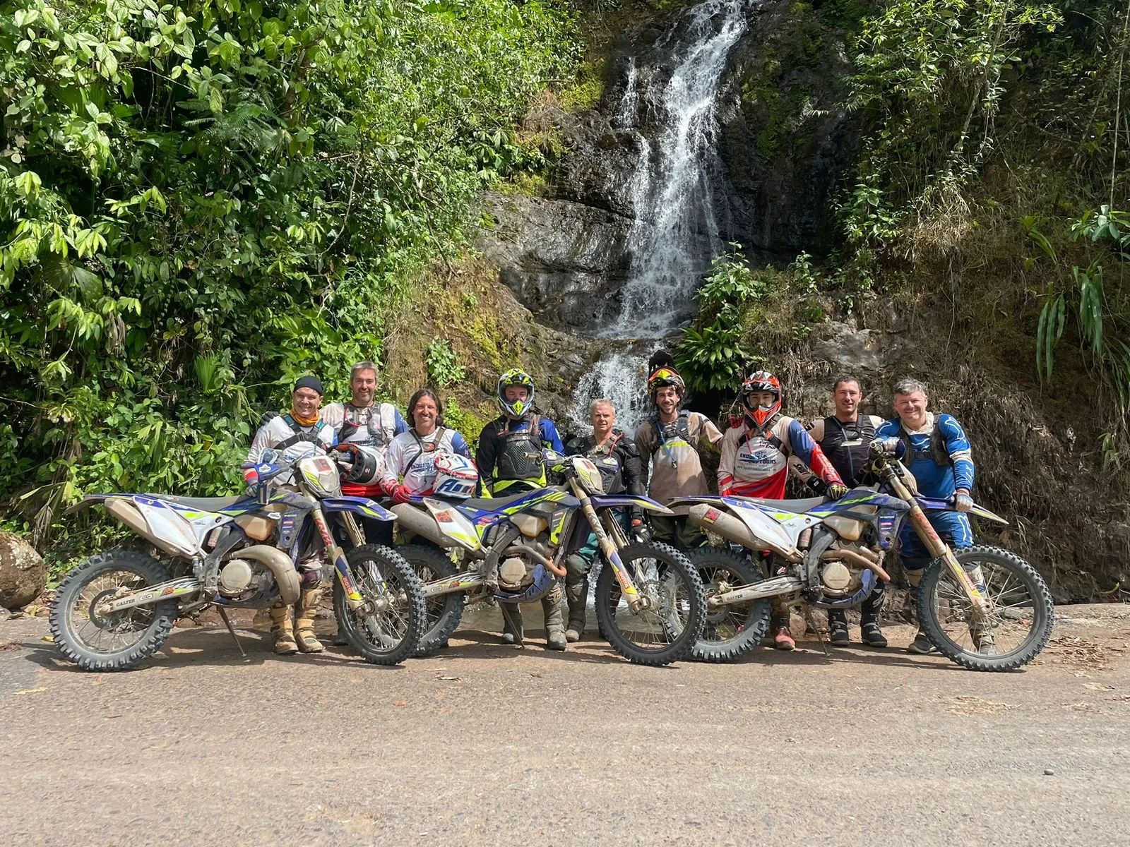 Dirtbike riders beside a jungle waterfall in Costa Rica